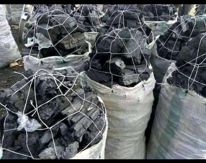Sacks of charcoal bundled in netting at a market